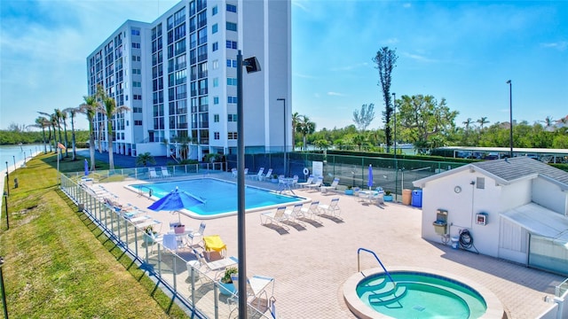 view of swimming pool featuring a community hot tub and a patio area