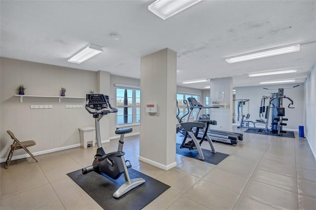 workout area with a textured ceiling and light tile patterned flooring