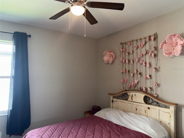 bedroom with ceiling fan and a textured ceiling