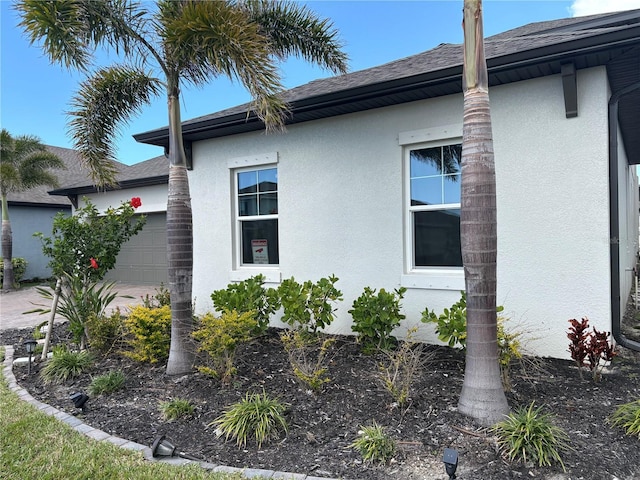 view of property exterior with an attached garage and stucco siding