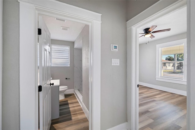 bathroom featuring hardwood / wood-style floors, toilet, and ceiling fan