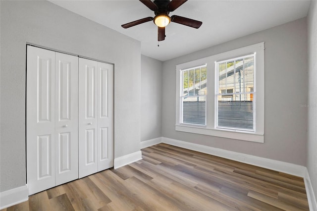 unfurnished bedroom featuring a closet, ceiling fan, and light wood-type flooring