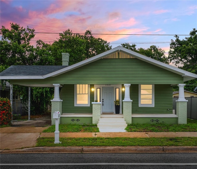 1010 E Lake Ave, Tampa, FL 33605 - view of front of home with crawl space, driveway, covered porch, a chimney, and an attached carport