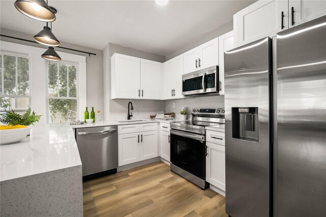 1010 E Lake Ave, Tampa, FL 33605 - kitchen featuring stainless steel appliances, a sink, white cabinetry, and light wood-type flooring
