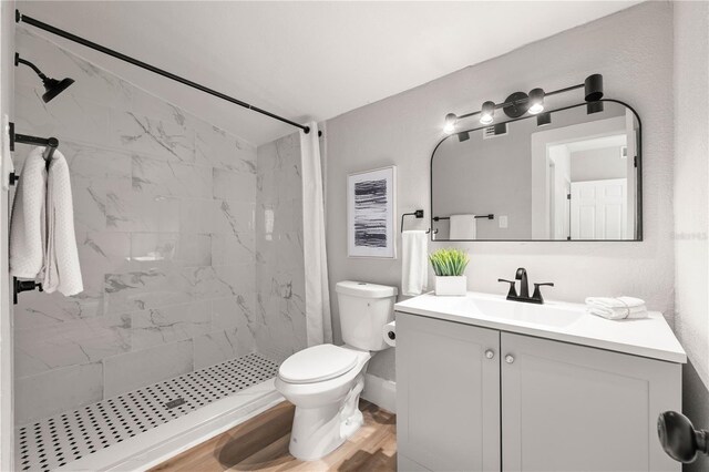 1010 E Lake Ave, Tampa, FL 33605 - bathroom with vanity, toilet, a marble finish shower, wood finished floors, and lofted ceiling