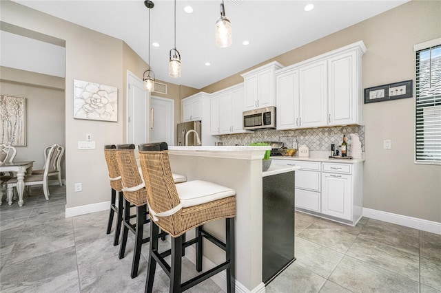 kitchen featuring white cabinetry, appliances with stainless steel finishes, and a kitchen island with sink