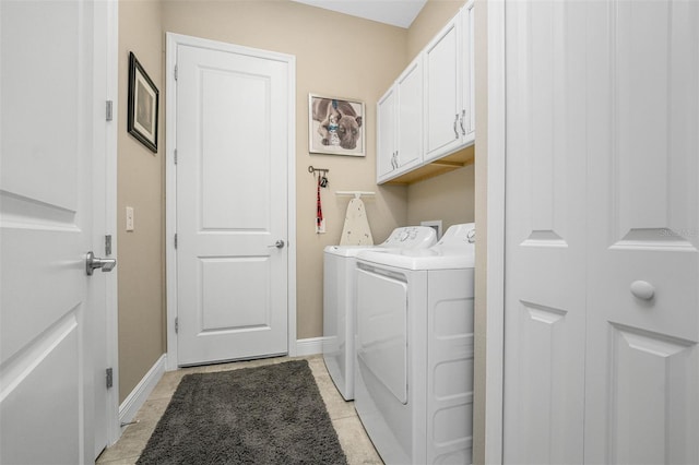 laundry room featuring cabinets, separate washer and dryer, and light tile patterned floors