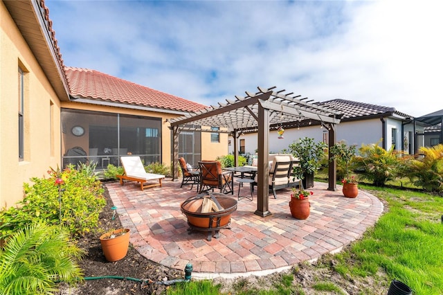 view of patio / terrace with a pergola, a sunroom, and an outdoor fire pit