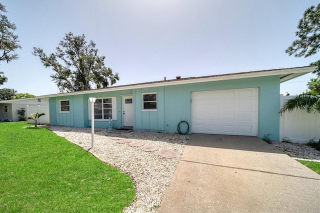 ranch-style home with a garage and a front lawn