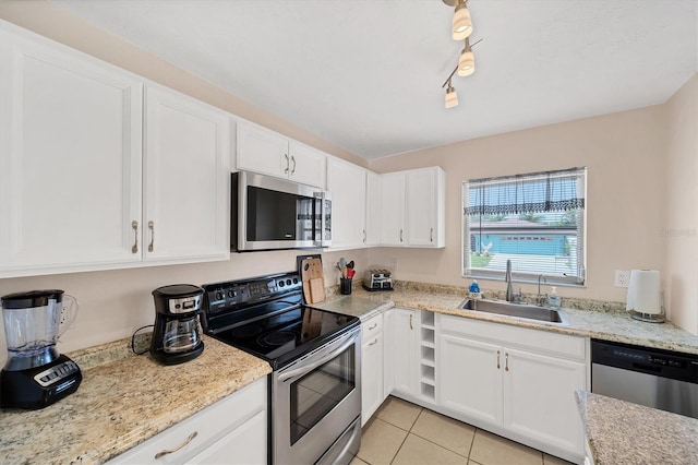 kitchen featuring light tile patterned floors, appliances with stainless steel finishes, sink, and white cabinets