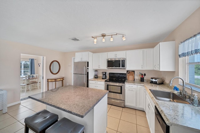 kitchen featuring sink, a breakfast bar area, white cabinetry, a center island, and stainless steel appliances