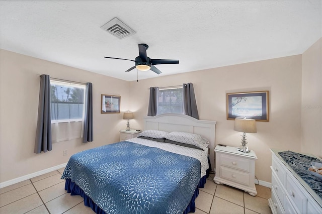 tiled bedroom featuring ceiling fan and a textured ceiling