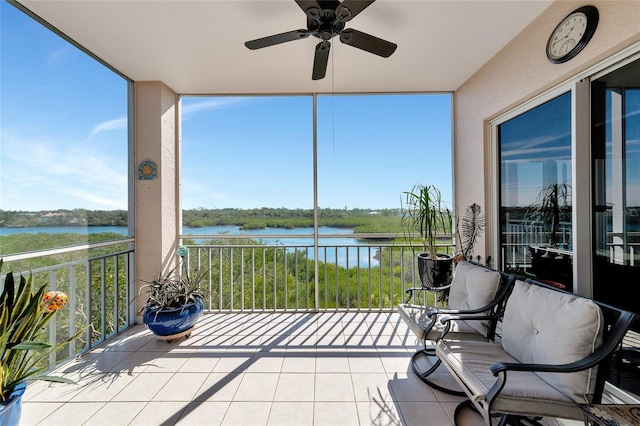 sunroom featuring a water view, plenty of natural light, and ceiling fan