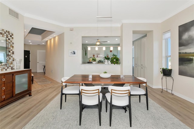 dining space featuring ornamental molding and light hardwood / wood-style floors