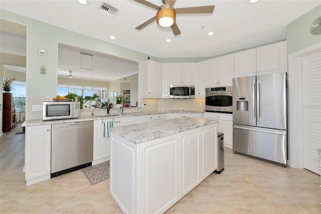 kitchen with white cabinetry, sink, kitchen peninsula, and appliances with stainless steel finishes