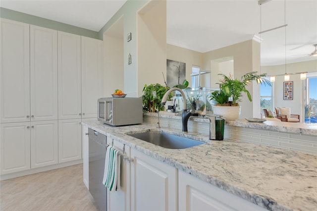 kitchen with light stone countertops, white cabinetry, appliances with stainless steel finishes, and sink