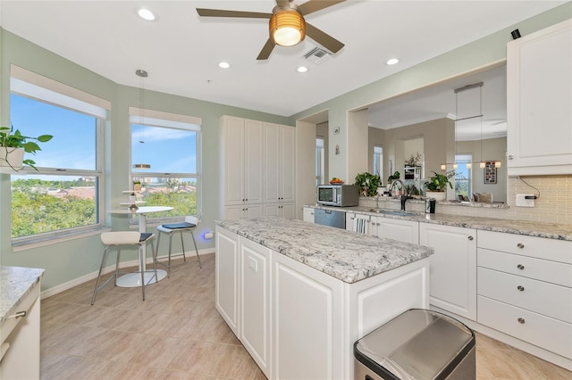 kitchen with hanging light fixtures, decorative backsplash, and white cabinets