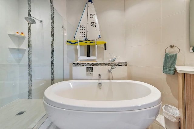 bathroom featuring tile walls, vanity, and plus walk in shower