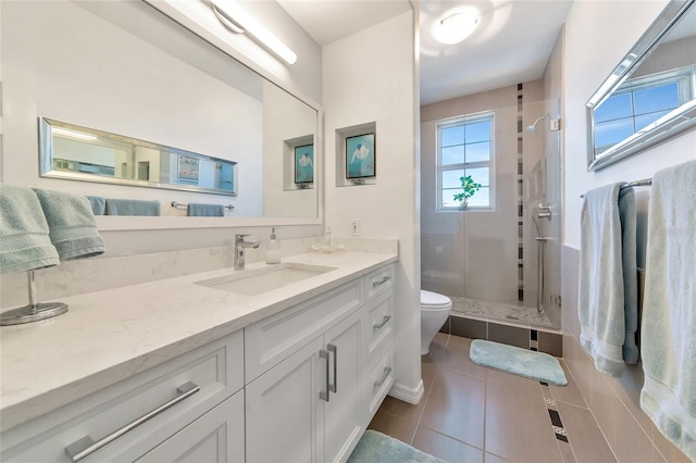 bathroom with tile patterned flooring, vanity, toilet, and walk in shower