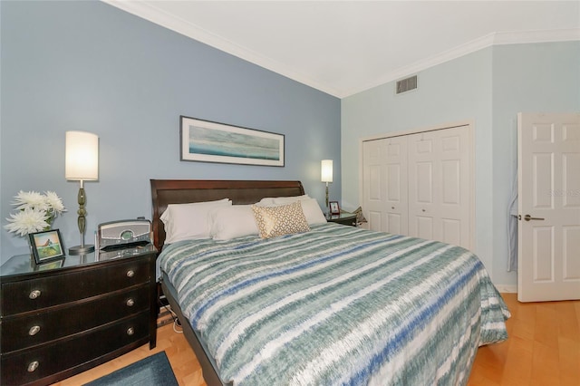 bedroom featuring ornamental molding, a closet, and light wood-type flooring