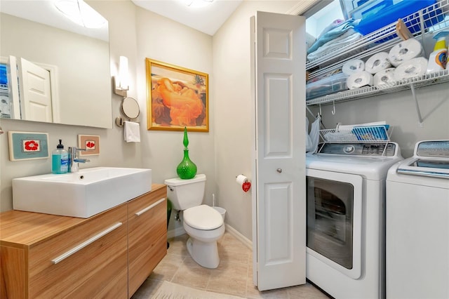 bathroom with vanity, toilet, tile patterned flooring, and washing machine and dryer