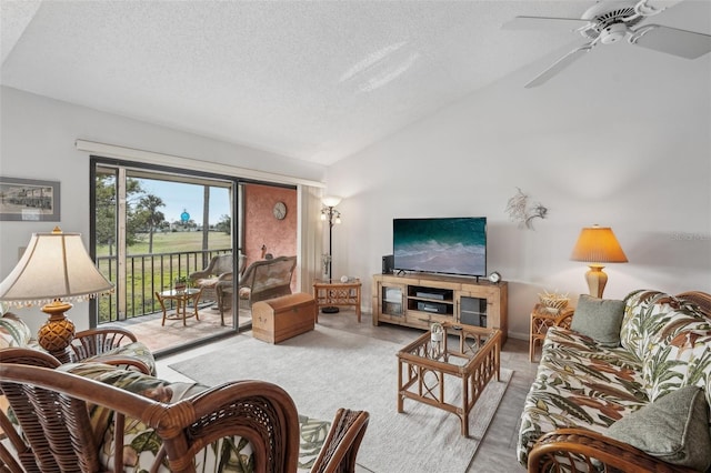 living room featuring ceiling fan, lofted ceiling, and a textured ceiling