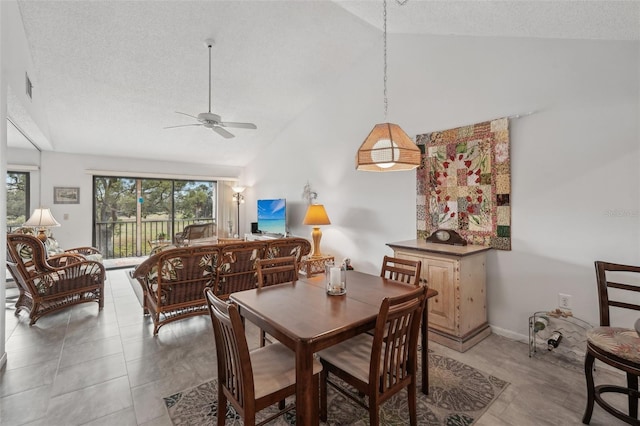 dining space featuring vaulted ceiling, ceiling fan, and a textured ceiling