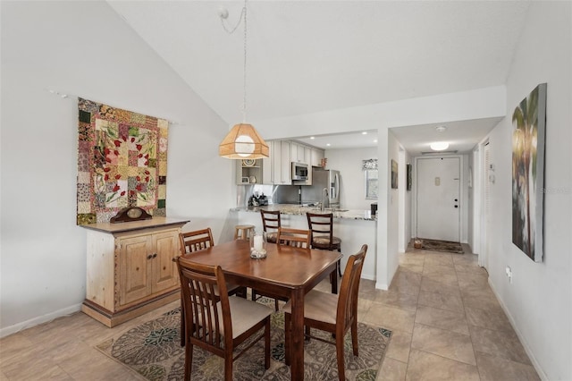 dining space featuring light tile patterned floors and high vaulted ceiling