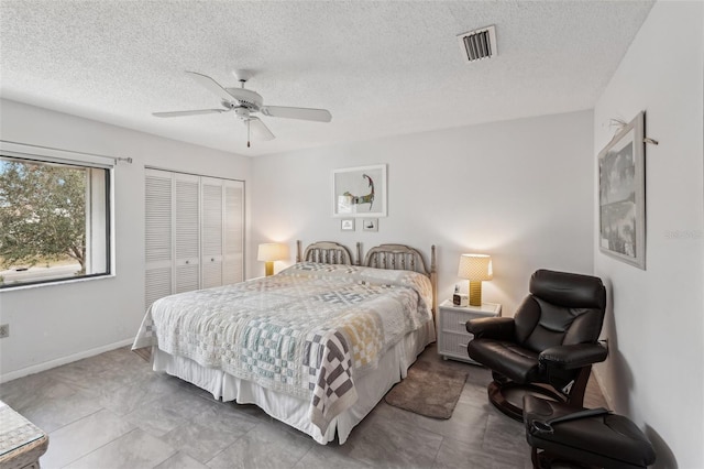 bedroom with ceiling fan, a closet, and a textured ceiling