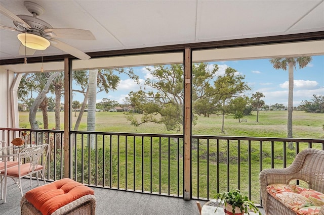 sunroom featuring ceiling fan, a healthy amount of sunlight, and a rural view