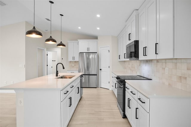 kitchen with sink, tasteful backsplash, white cabinetry, stainless steel appliances, and a kitchen island with sink