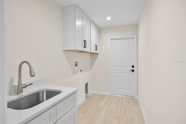 washroom featuring sink, electric dryer hookup, hookup for a washing machine, cabinets, and light wood-type flooring