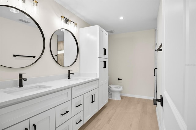 bathroom with hardwood / wood-style flooring, vanity, and toilet