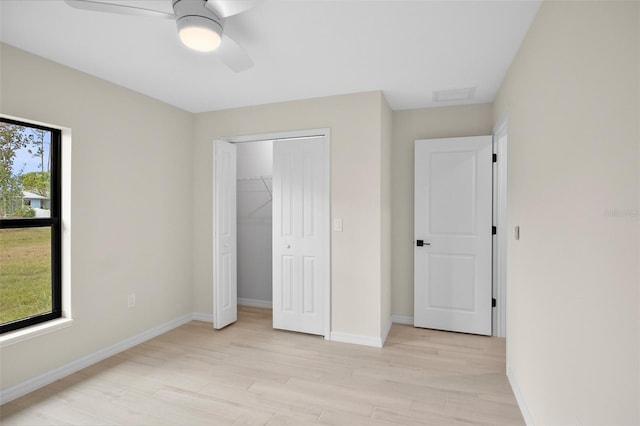 unfurnished bedroom with ceiling fan, a closet, and light wood-type flooring