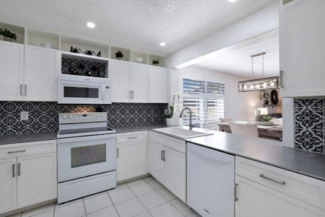 kitchen featuring light tile patterned flooring, decorative light fixtures, white cabinetry, sink, and white appliances