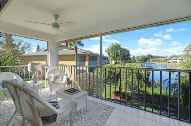 sunroom featuring a water view and a ceiling fan