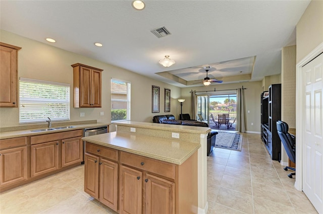 kitchen featuring dishwasher, sink, light tile patterned floors, ceiling fan, and a tray ceiling