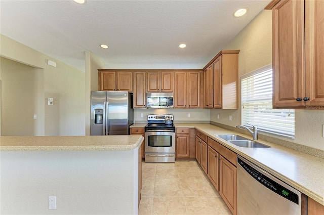 kitchen with appliances with stainless steel finishes, sink, and light tile patterned floors