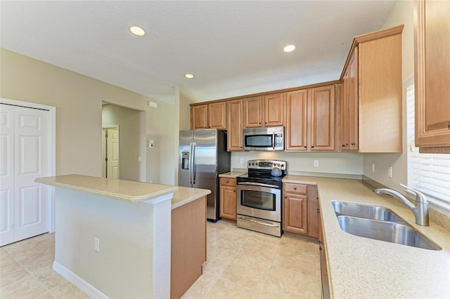 kitchen with stainless steel appliances, sink, a kitchen island, and light tile patterned floors