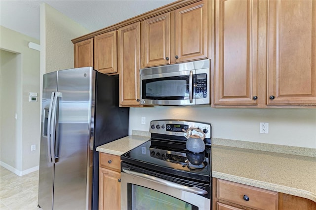 kitchen featuring light stone counters and stainless steel appliances