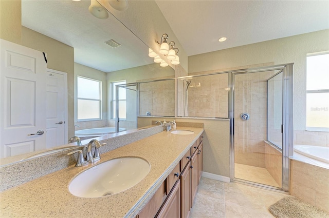 bathroom featuring tile patterned flooring, vanity, and shower with separate bathtub