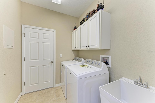 washroom featuring cabinets, sink, and washing machine and clothes dryer