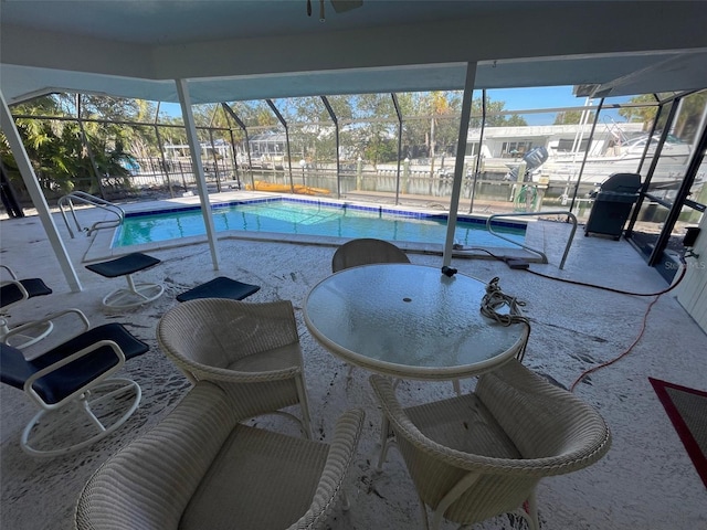 view of swimming pool with a grill, glass enclosure, and a patio area