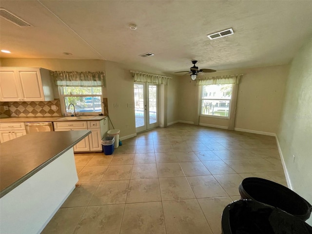 kitchen featuring sink, decorative backsplash, a healthy amount of sunlight, and light tile patterned flooring