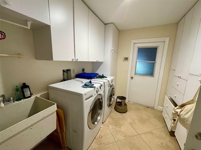 washroom featuring cabinets, washing machine and dryer, sink, and light tile patterned flooring