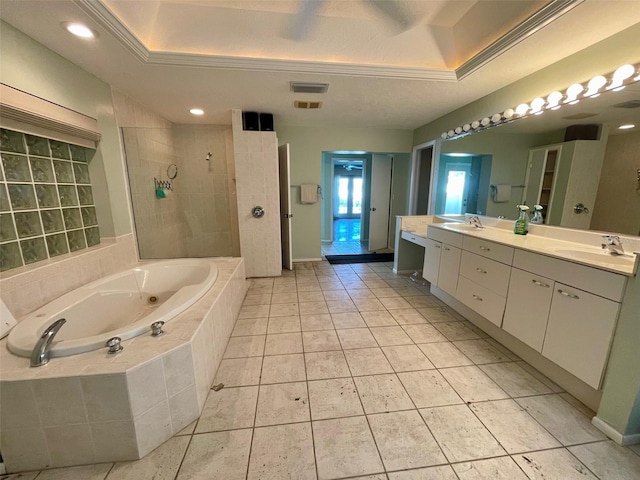 bathroom featuring tile patterned floors, vanity, a tray ceiling, and shower with separate bathtub