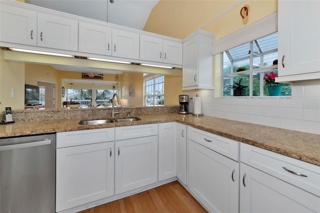 kitchen featuring sink, light hardwood / wood-style flooring, dishwasher, light stone countertops, and white cabinets