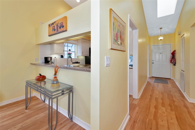 hallway featuring sink and light wood-type flooring