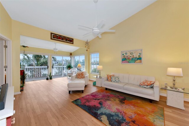 living room with hardwood / wood-style flooring, ceiling fan, and lofted ceiling