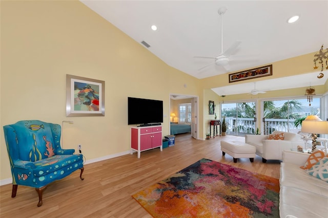 living room with hardwood / wood-style floors, high vaulted ceiling, and ceiling fan